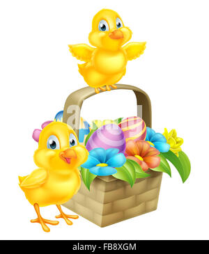 Cartoon Easter Chicks baby chicken birds, chocolate painted Easter Eggs and spring flowers in an Easter basket hamper Stock Photo