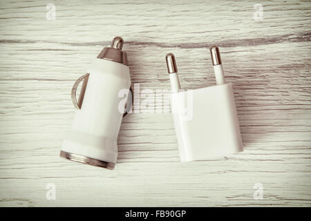 Usb car charger on the wooden background. Charging device. Stock Photo