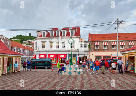 Scene of daily life in the capital of Grenada, with people walking on the sidewalks and traffic in the streets. Stock Photo
