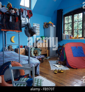 Colorful play tent in children's blue nineties bedroom with metal bunk beds Stock Photo