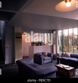 Pale blue sofas and armchair in an open plan nineties living space with a view of the kitchen Stock Photo