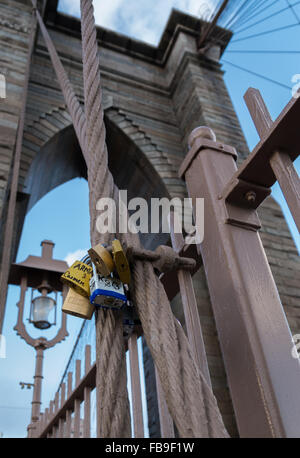 Love locks and padlocks that people have attached to Brooklyn Bridge in New York City with the tower in the background Stock Photo