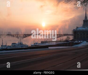 Frosty sunset with steam from the river. The City Of Krasnoyarsk, Siberia, Russia. Stock Photo