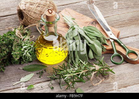 Fresh garden herbs and condiments on wooden table Stock Photo