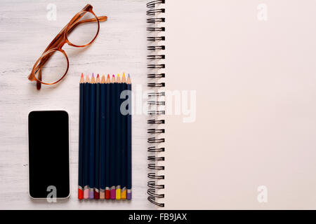 top view of a sketchbook with colored pencils arranged around on white  background Stock Photo by stoockking
