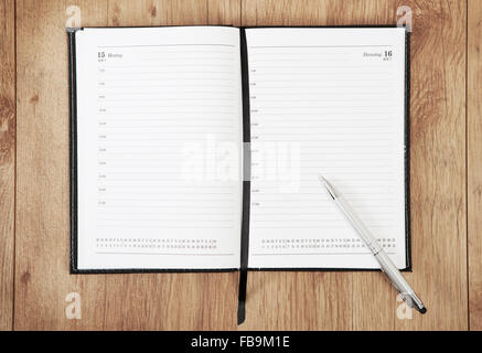 an unrecorded calendar with a pen lying on a wooden underground Stock Photo