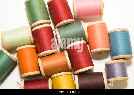 Many spools of thread of different colors on over white Stock Photo