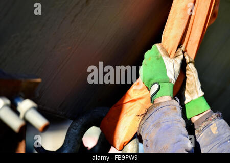 Construction worker hands on a heavy duty industrial chain Stock Photo