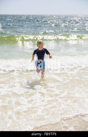 USA, Florida, Little boy (6-7) with scuba mask running against sea Stock Photo