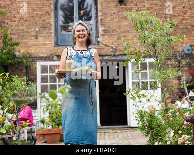 Sweden, Skane, Osterlen, Ostra Vemmerlov, Portrait of woman holding tray with food