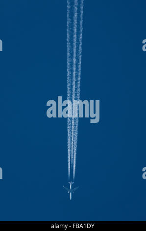 Airliner leaves a vapour trail in a clear blue sky Stock Photo