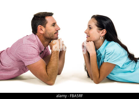 Happy couple laying on floor looking at each other Stock Photo