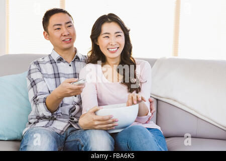 Happy couple sitting on sofa a Stock Photo