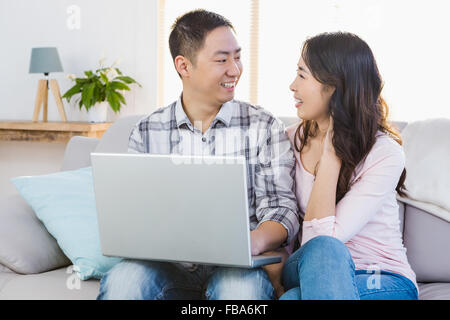 Happy young couple using laptop Stock Photo