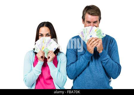 Portrait of couple hiding face with money Stock Photo