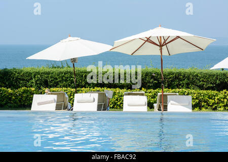 Sun loungers and parasols by the pool in Goa, India, Asia Stock Photo