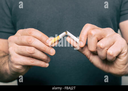 Quitting smoking - male hand crushing cigarette Stock Photo