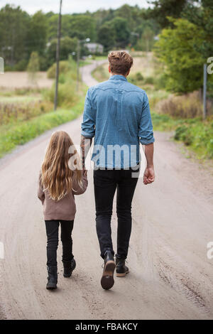 Finland, Uusimaa, Raasepori, Karjaa, Father walking with daughter (6-7) along country road