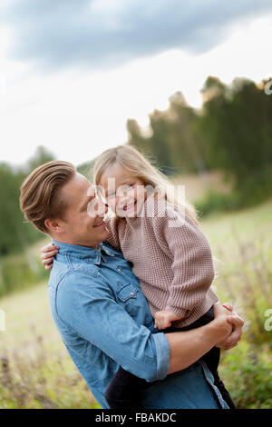 Finland, Uusimaa, Raasepori, Karjaa, Father holding in arms his daughter (6-7)