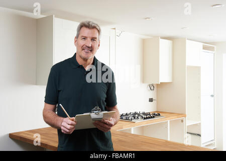 Carpenter Installing Luxury Fitted Kitchen Stock Photo