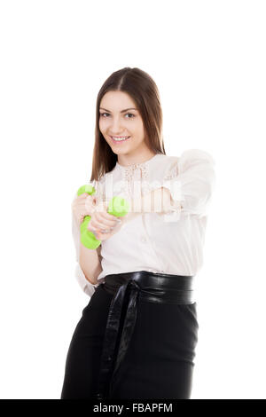 Young smiling businesswoman in black skirt and white shirt trains biceps lifting dumbbell weights, workout, business training, s Stock Photo