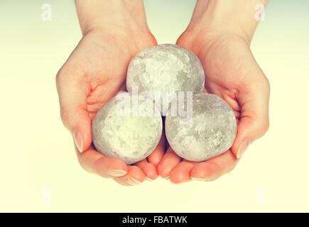 Female hands holding round halite rock salt crystals for alternative medicine Stock Photo