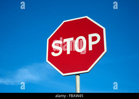 Red stop sign against a blue sky. Stock Photo