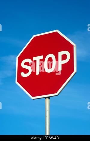Red stop sign against a blue sky. Stock Photo