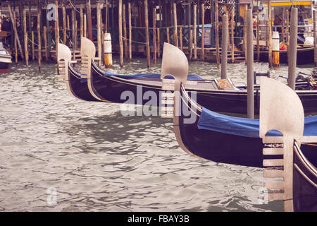 many gondolas close to the pier in Venice, focus on second one Stock Photo