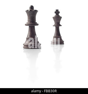 Chess. Black Queen and King out of focus and their shadows reflection on white background. Winner, power, competition or leaders Stock Photo