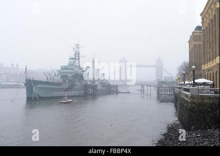 England, London, River Thames. Snow falls on HMS Belfast and Tower Bridge. Stock Photo