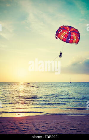 Retro stylized paragliders at sunset, summer adventure concept, Langkawi Island in Malaysia. Stock Photo