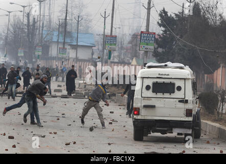 (160114) -- SRINAGAR, Jan. 14, 2016 (Xinhua) -- Kashmiri protesters throw stones towards Indian police during a protest against the killing of Owais Bashir Malik, an engineering student, in Srinagar, summer capital of Indian-controlled Kashmir, Jan. 14, 2016. Indian police fired warning shots and tear gas shells to disperse hundreds of Kashmiri protesters who had blocked road to Srinagar airport and shouting anti-India slogans after the body of a college student with his throat slit was found in the Indian-controlled Kashmir. The protesters accused the Indian army of torturing and killing the Stock Photo