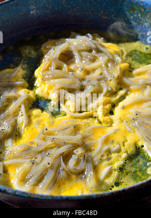 South Island New Zealand's  whitebait being fried into whitebait  fritters or patties in a frying pan with eggs ready to be served, Haast,New Zealand Stock Photo