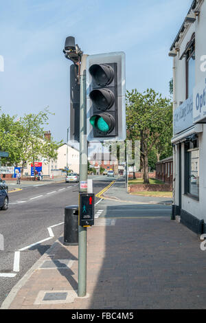 Pedestrian Puffin Crossing with traffic light on green with pedestrian sensors above the lights and a push button on the post. Stock Photo