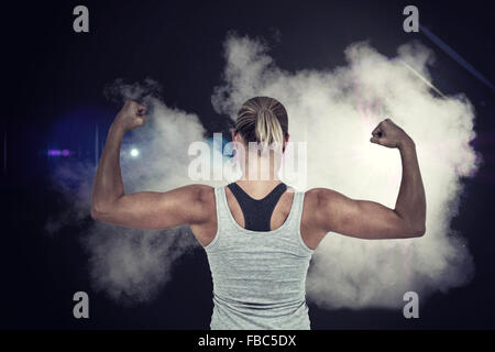 Composite image of rear view of muscular woman flexing muscles Stock Photo