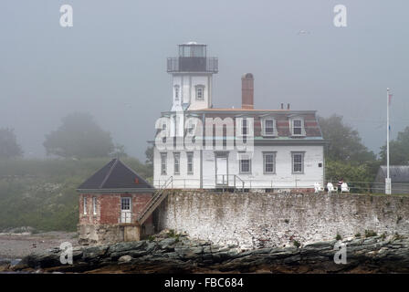 Rose Island lighthouse in early morning summer fog inside Newport Harbor, Rhode Island. Stock Photo