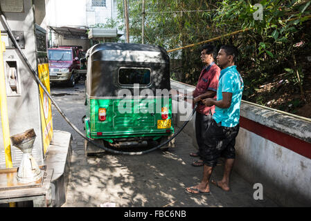 A petrol pump attendant fills up with fuel at one of the many Government-owned Ceypetcc outlets in Kandy,  Sri Lanka.  CEYPETCO. Stock Photo