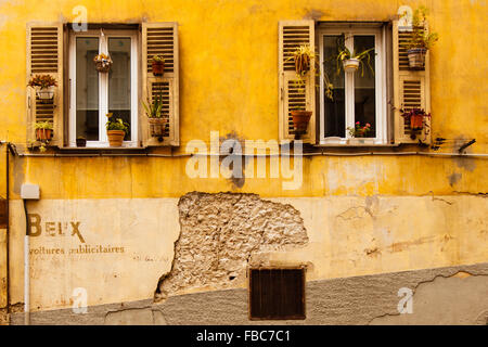 Typical shuttered windows and yellow wall in the Vielle Ville in Nice France