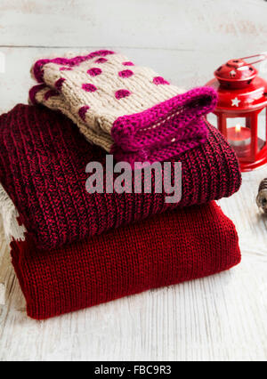 Cozy Fluffy Woolen Sweaters and Knitted Hand Warmers  for Winter Time with Christmas Lantern in the Background Stock Photo