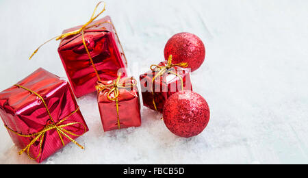 Red Christmas Presents Ornaments and Glitter Balls in the Snow Stock Photo