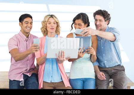 Composite image of casual businesspeople using digital tablet with colleagues behind in office Stock Photo