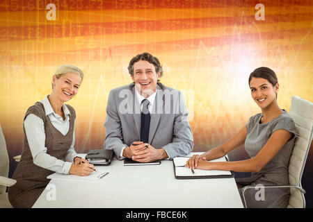 Composite image of portrait of smiling business people sitting at conference table Stock Photo