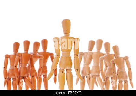 Wooden dummy character standing between two different colored teams. Isolated on white. Stock Photo