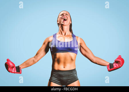 Composite image of winning fighter with arms outstretched Stock Photo