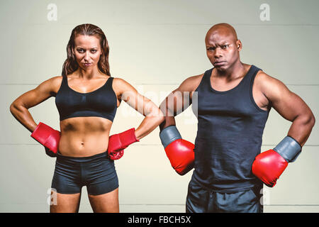 Composite image of portrait of male and female boxers with hands on hip Stock Photo