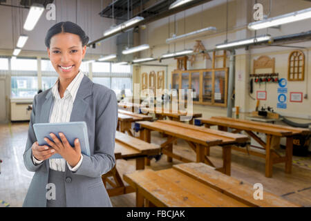Composite image of businesswoman using a tablet with colleagues behind in office Stock Photo