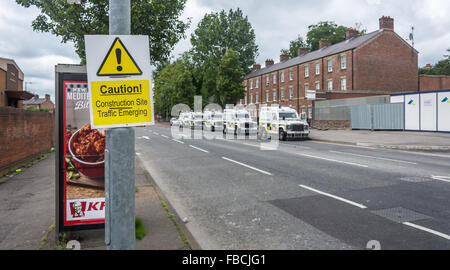 Caution sign in front of PSNI land rovers in New Lodge area of Belfast ahead of a Republican parade. Stock Photo