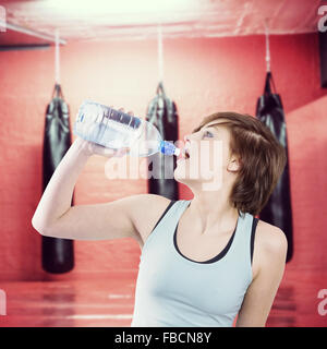 Composite image of pretty brunette drinking water Stock Photo