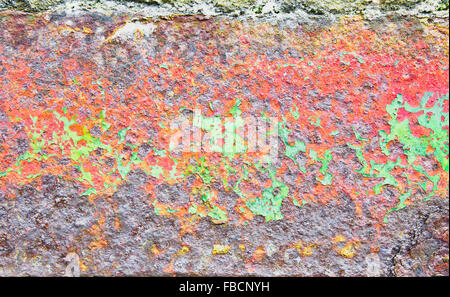 Peeling green and red paint on a severely rusted metal surface Stock Photo